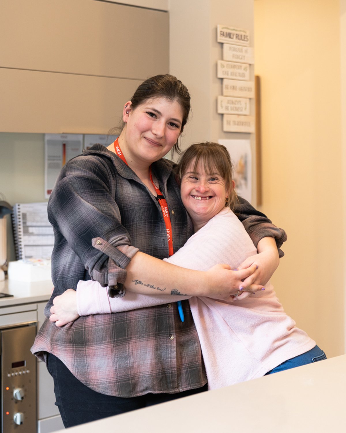 Two woman stand and smile in a kitchen