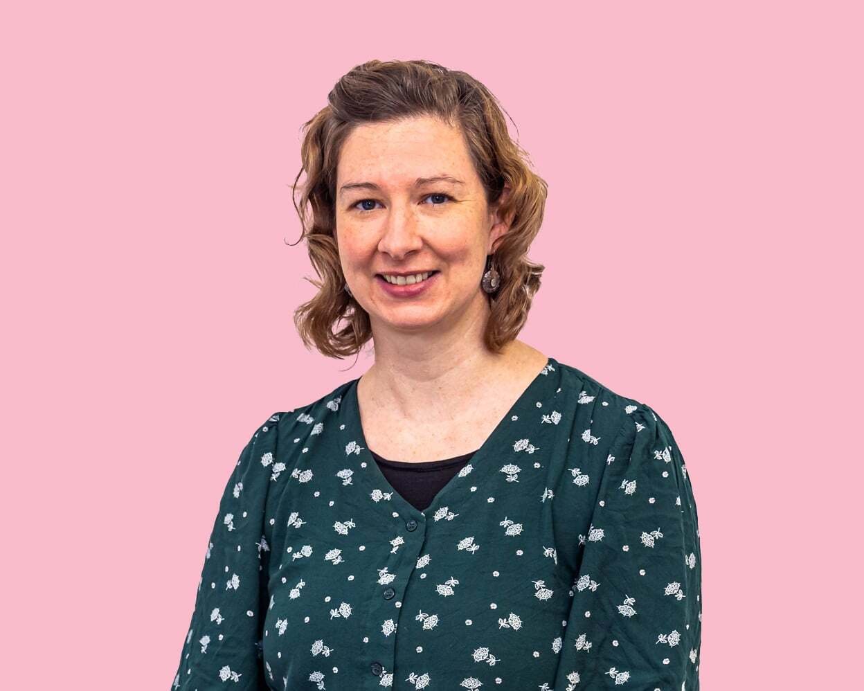 Woman with printed top smiles at camera