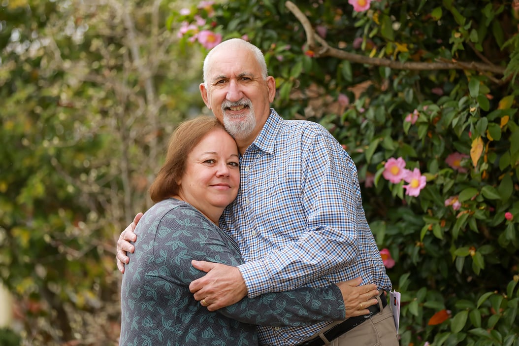 A  man and woman embracing in a hug.