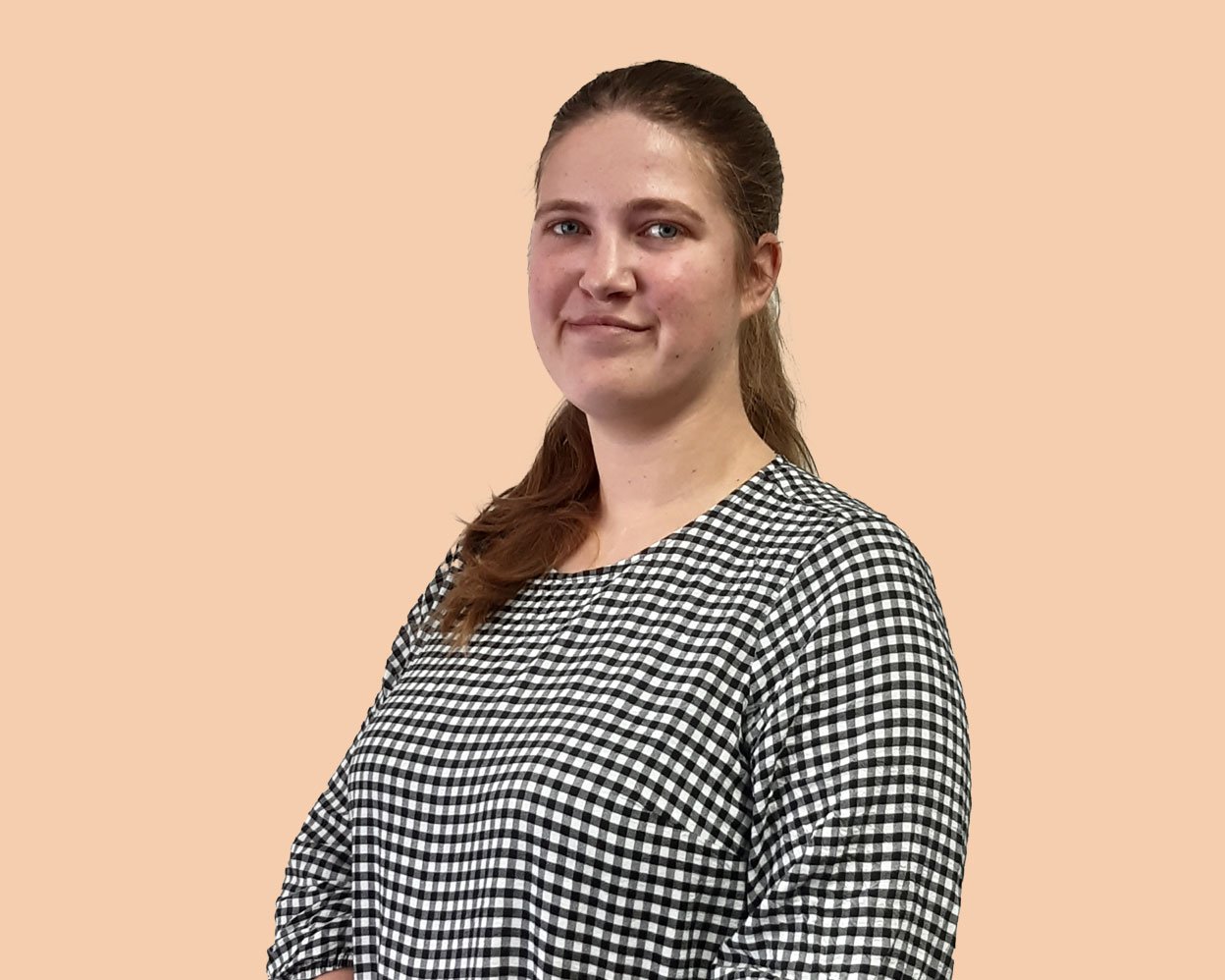 A woman in a gingham dress looks at camera