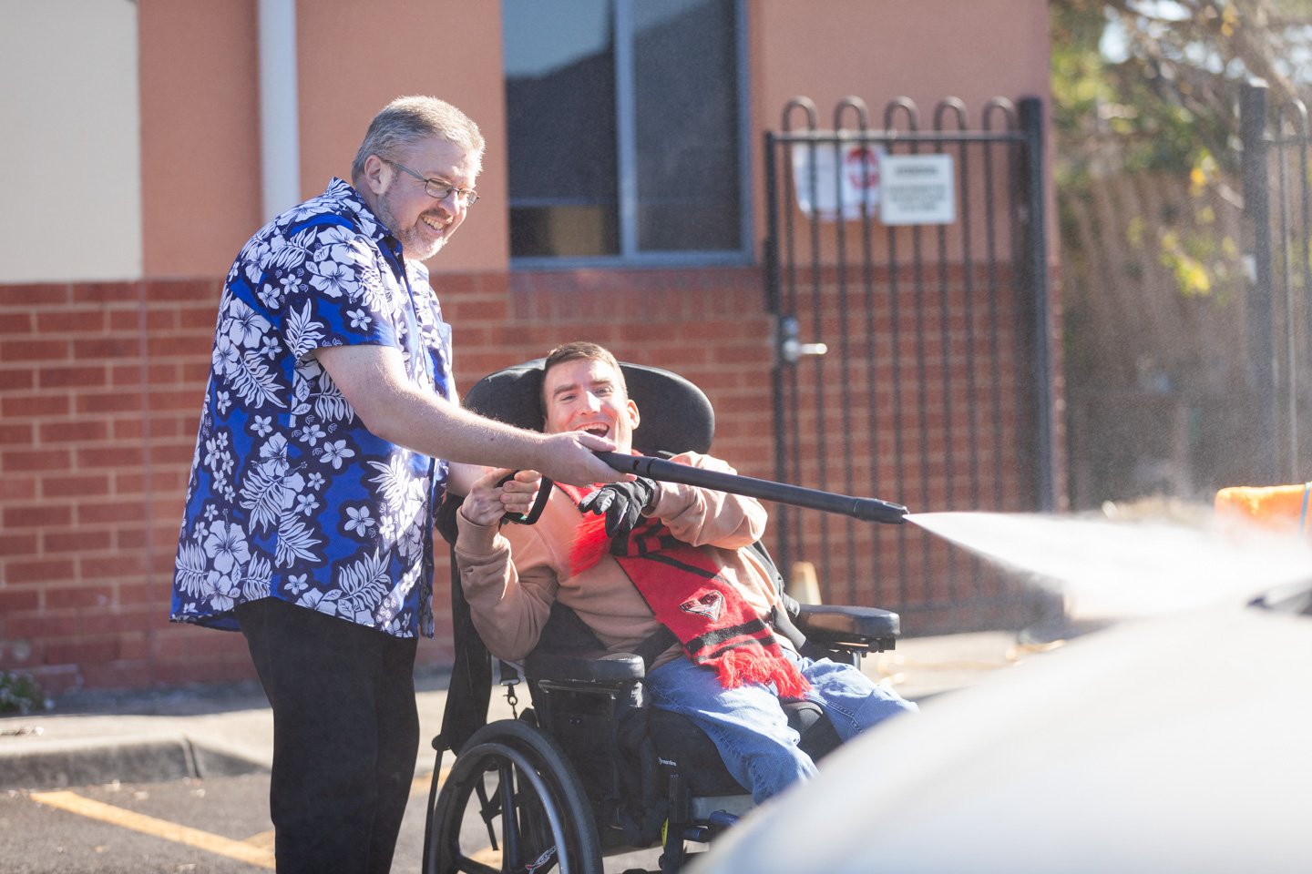 A man guiding another man in a wheelchair.