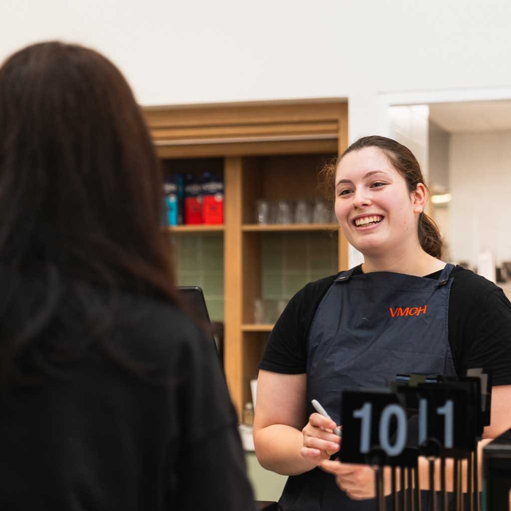 a woman serves a customer in a cafe