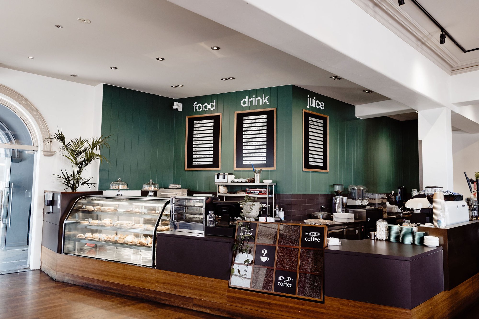 Inside VMCH Wangaratta Cafe class counter with three menu boards on the back dark green wall