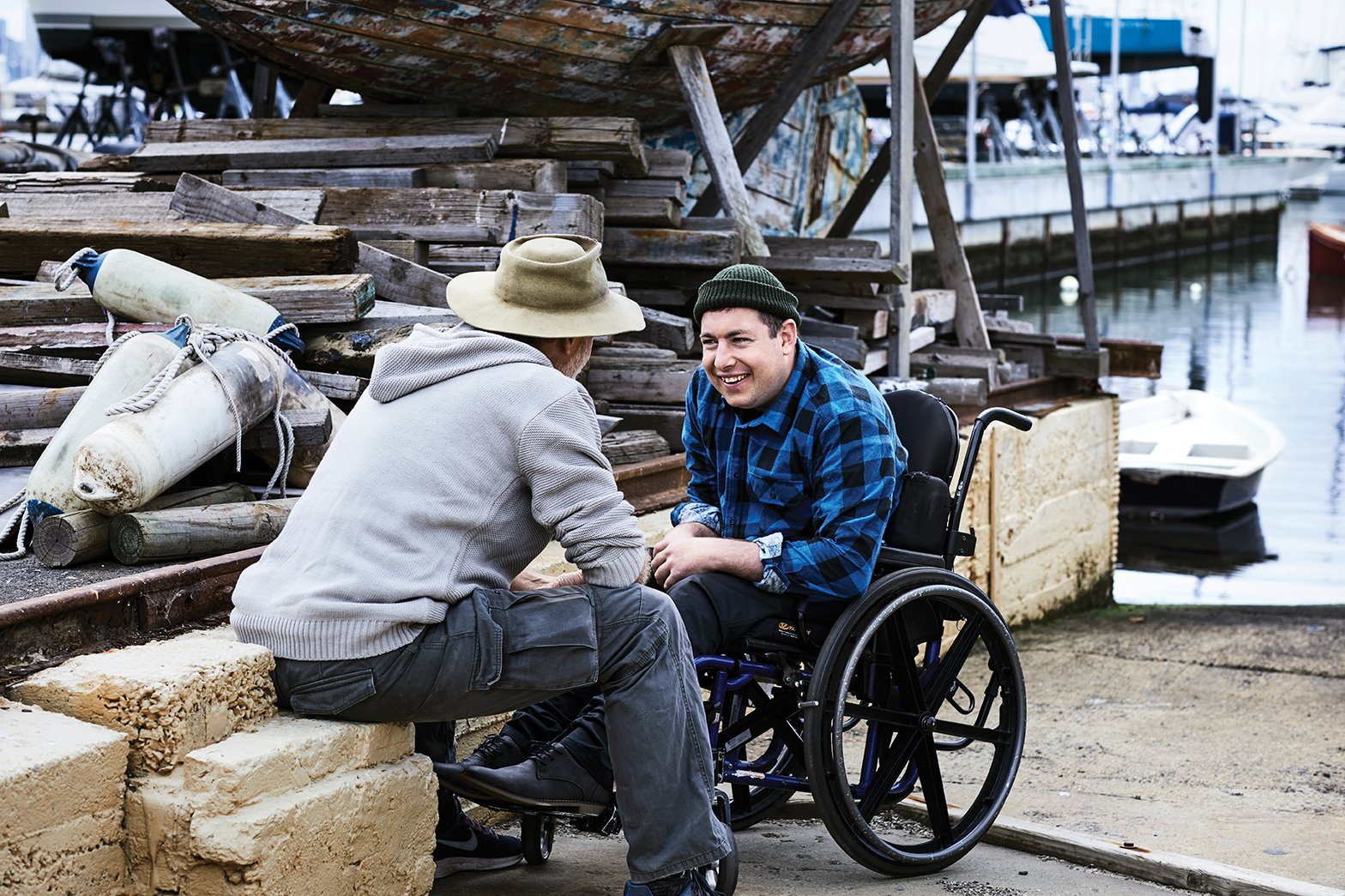 A person using a wheelchair chats with a companion while enjoying time away during a supported short-term respite experience.