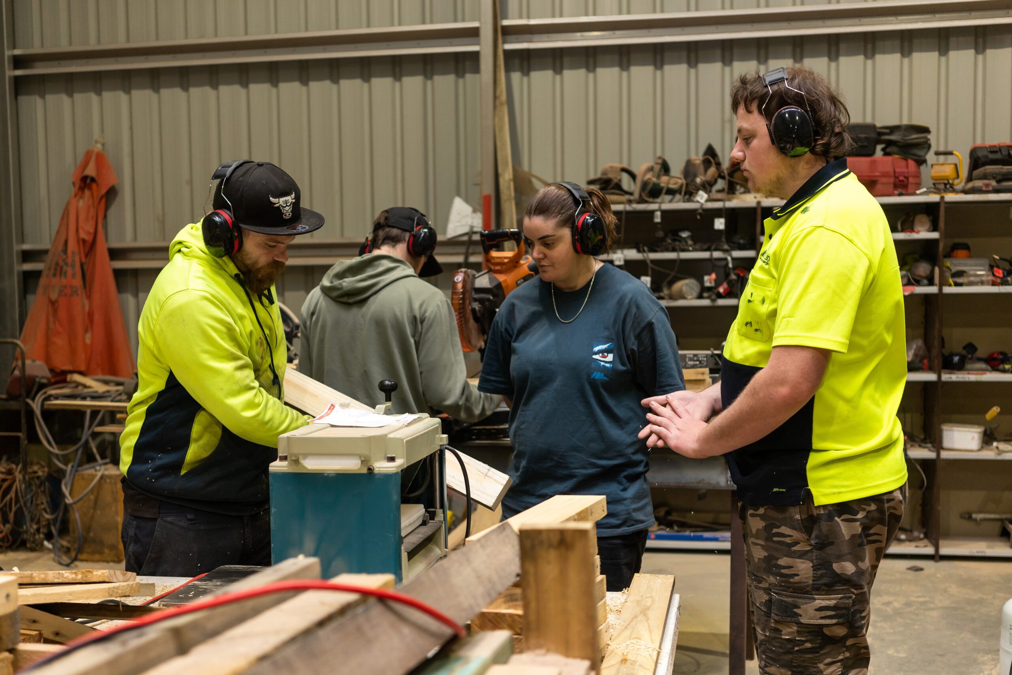 Two students watching how to use a piece of machinery in a workshop.