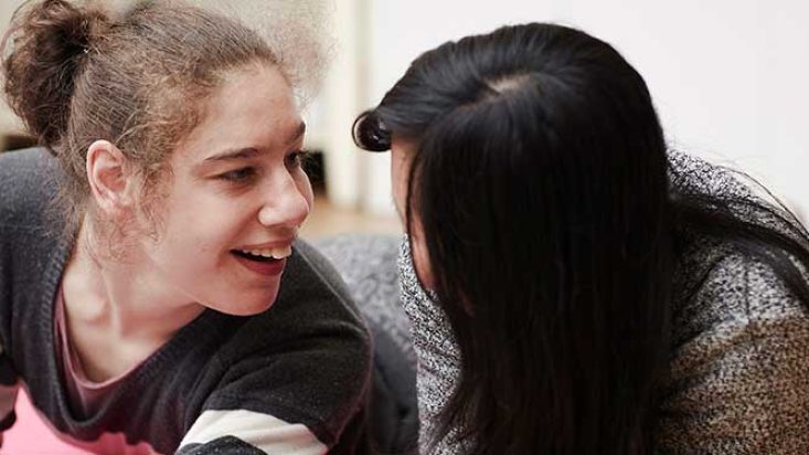 Two people share a friendly moment while spending time together during supported activities.