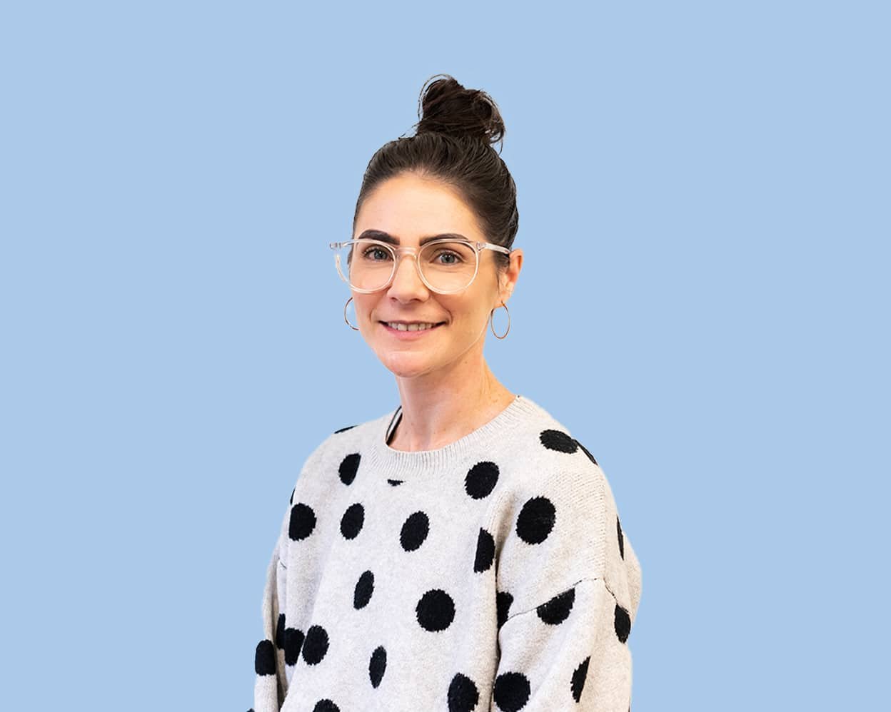 A woman wearing glasses smiles at camera