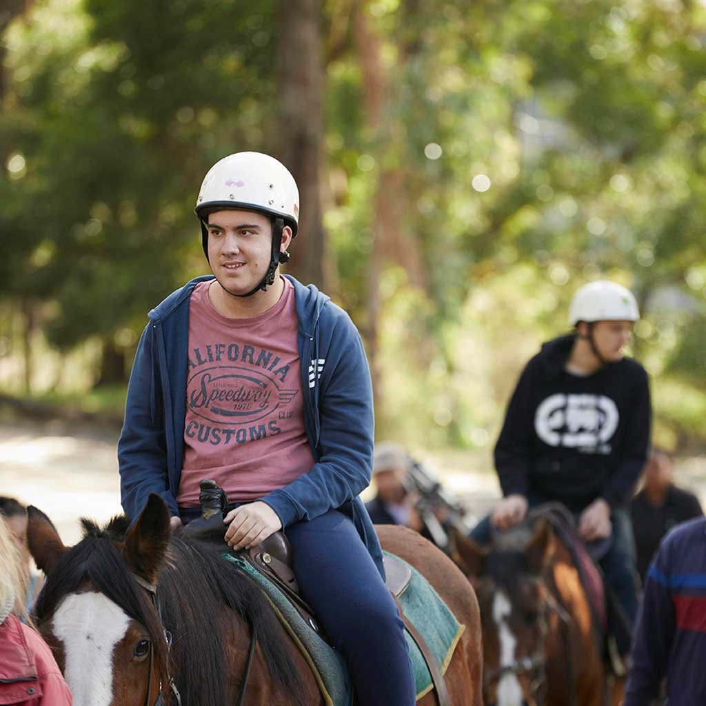 a young man riding a horse
