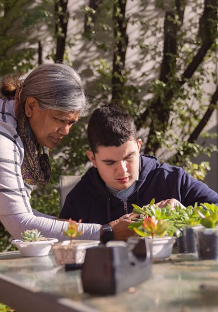 Two people sit at a table and garden together